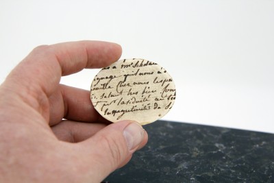 Fragment de texte manuscrit au dos de la carte à jouer découpée